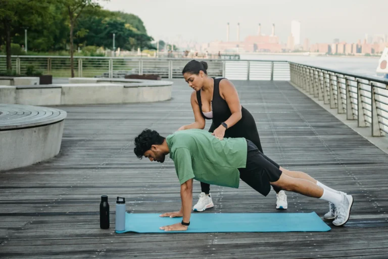 Un coach avec un participant qui réalise un exercice de renforcement musculaire